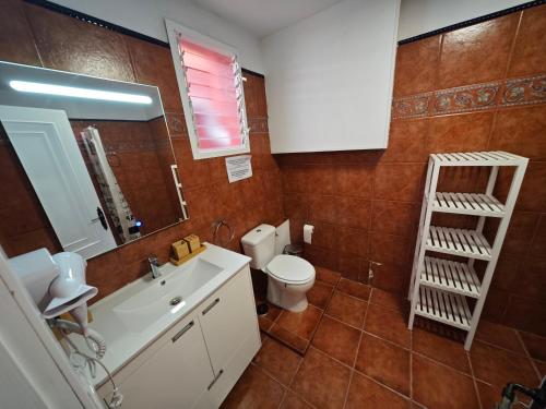 a bathroom with a sink and a toilet and a mirror at La concha in La Laguna