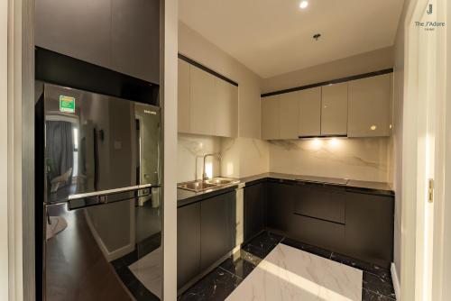 uma cozinha com armários brancos e um frigorífico em Luxury Apartment Altara em Quy Nhon