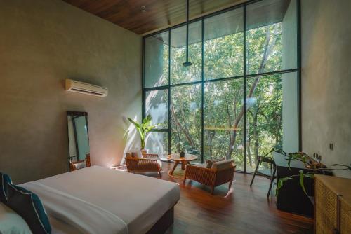 a bedroom with a bed and a large window at Piece Lio Resort from Japan in El Nido