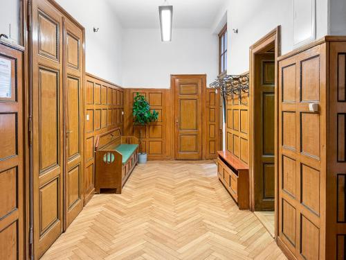 feworld - big living - city center Klagenfurt في كلاغنفورت: غرفة كبيرة بأبواب خشبية وأرضية خشبية