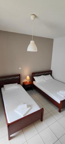two beds sitting next to each other in a room at KANALI HOLIDAYS APARTMENT in Kanali