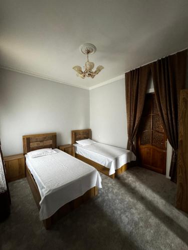 1 dormitorio con 2 camas y techo en Zaynullo Guest House, en Bukhara