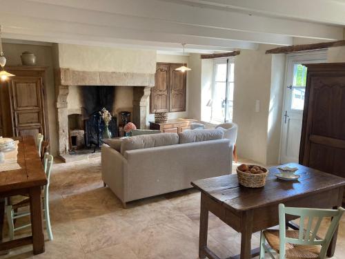 un salon avec un canapé et une cheminée dans l'établissement Miller house in a water mill from the 12th century, à Négreville