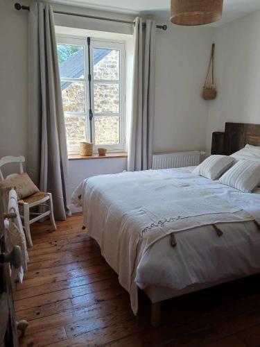 une chambre avec un grand lit et une fenêtre dans l'établissement Miller house in a water mill from the 12th century, à Négreville