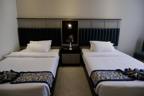 a hotel room with two beds and a table at D'more Kuakata Hotel & Resort in Kuākāta