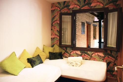 un divano bianco in una stanza con finestra di Apartamentos Inside Casa de la Alberca a Granada