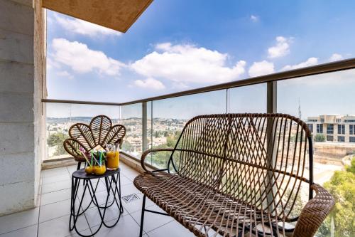 a balcony with a rattan chair and a table at Isrentals Haneviim - ApartHotel In City Center in Jerusalem