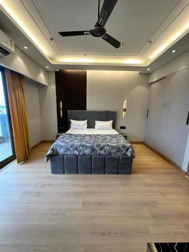 a bedroom with a large bed with a ceiling fan at The Urban Suites in Ghaziabad