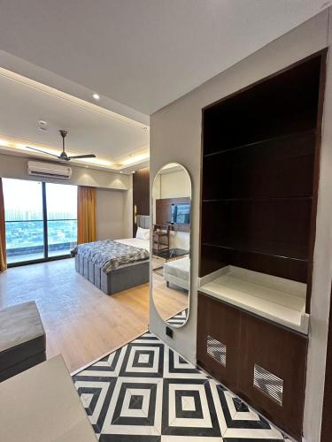 a room with a large television and a bedroom at The Urban Suites in Ghaziabad