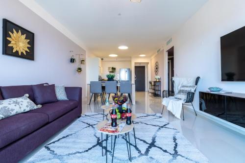 a living room with a purple couch and a table at Isrentals Haneviim - ApartHotel In City Center in Jerusalem