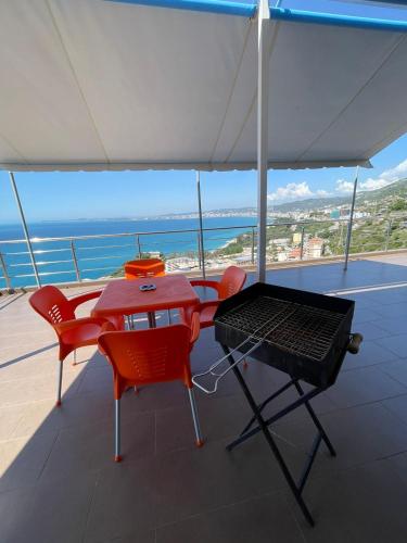 a table and chairs and a grill on a balcony at Panorama Sea View Apartments in Vlorë