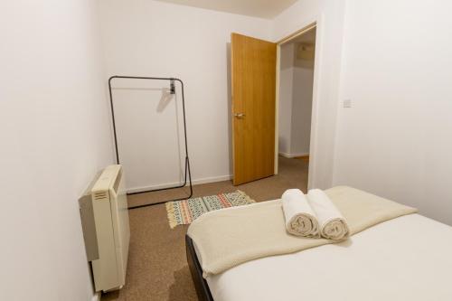ein Schlafzimmer mit einem Bett mit zwei Handtüchern darauf in der Unterkunft Comfy Chic 2Bed Apartment in Sheffield City Centre in Sheffield