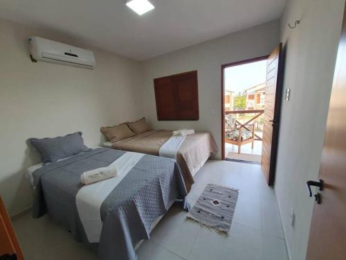 a hotel room with two beds and a balcony at Casa Icaria Atins MA in Atins