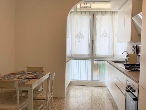 a small kitchen with a table and a window at Appartamento Jesolo Piazza Drago in Lido di Jesolo