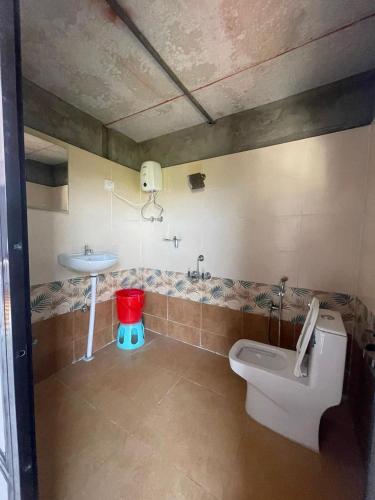 a bathroom with a toilet and a sink at 5 Kesar Baug Resort in Ānjarle