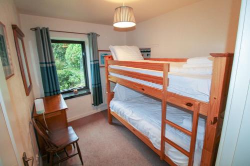 sypialnia z łóżkiem piętrowym, biurkiem i oknem w obiekcie Barn Owl Cottage, Lindale w mieście Lindale