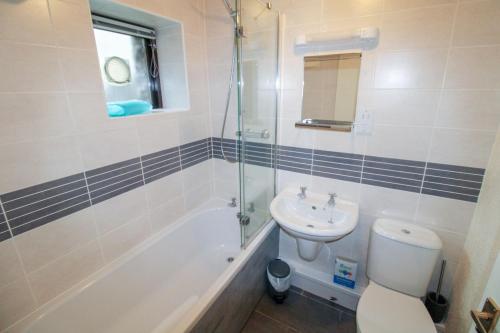 La salle de bains est pourvue d'un lavabo, de toilettes et d'une douche. dans l'établissement Barn Owl Cottage, Lindale, à Lindale