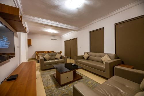 a living room with couches and a flat screen tv at Lakowe Lakes Hotel, Golf and Country Estate by NEWMARK in Lagos