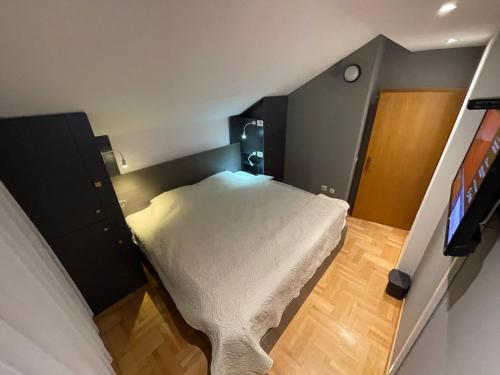 a small bedroom with a bed and a television at Town hostel in Peje
