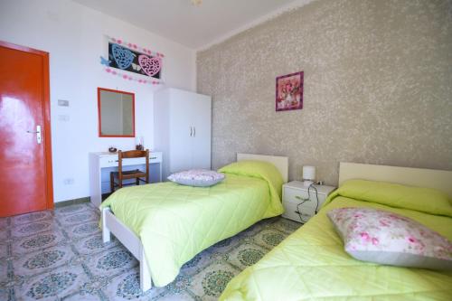 a bedroom with two beds with green sheets at La Casa Dei Nonni in Agerola