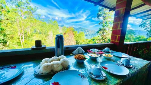 una mesa con platos de comida delante de una ventana en NETHSARA cottage, en Ella