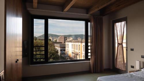 een slaapkamer met een groot raam met uitzicht bij Penthouse Rooms Marigliano - Eleganza sopra le nuvole in Marigliano