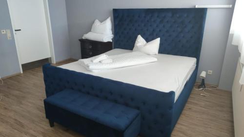 uma cama com uma cabeceira azul e uma cadeira azul em Zimmer in Ramstein em Ramstein-Miesenbach