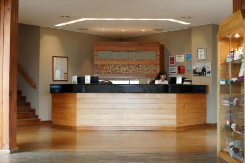 a woman sitting at the counter of a restaurant at Mirador del Lago Hotel in El Calafate
