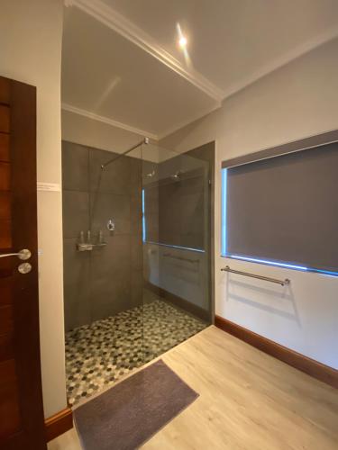 baño con ducha y puerta de cristal en River Daze, en Stilbaai