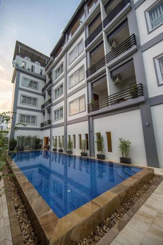 a hotel swimming pool in front of a building at Nico's Hotel 2 in Siem Reap