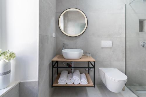 a bathroom with a sink and a toilet and a mirror at Bed and Breakfast Palac in Baška Voda