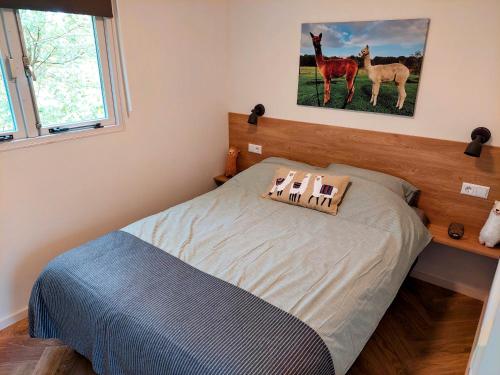 1 dormitorio con 1 cama con 2 caballos en la pared en Erfgoed de Boemerang - Chalet Alpaca, en Meppen