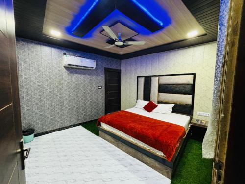 una camera con un letto e un soffitto blu di hotel chahat palace ad Agra