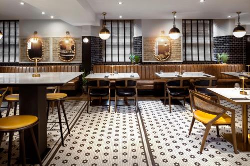 a restaurant with tables and chairs and mirrors at Courtyard by Marriott Edinburgh in Edinburgh