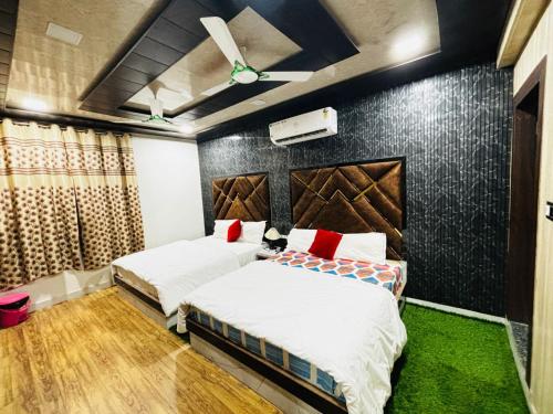 hotel chahat palace في آغْرا: غرفة نوم بسريرين وجدار اسود