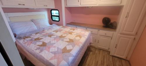 a small bedroom with a quilt on a bed at Logan Martin Lake Sunroom in Lincoln