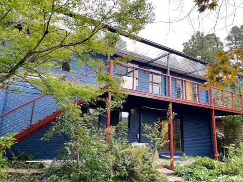 a blue house with a balcony on the side of it at Morisset Cottage Blackheath in Blackheath