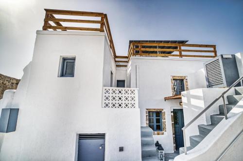 a white house with a blue door and stairs at 360o 2BD Panoramic Apartment in Akrotiri