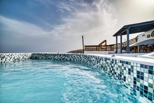a swimming pool with blue water and a slide at 360o 2BD Panoramic Apartment in Akrotiri
