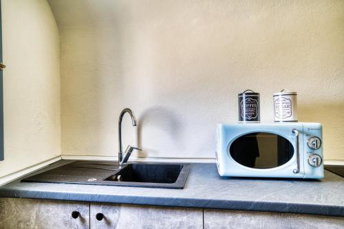 a kitchen counter with a microwave and a sink at 360o 2BD Panoramic Apartment in Akrotiri