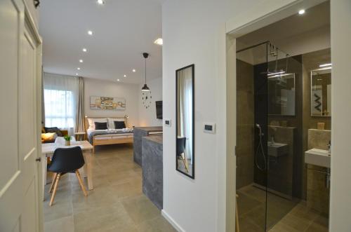 a living room with a glass shower and a couch at Black & White Studios in Bale