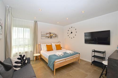 a bedroom with a bed and a tv and a chair at Black & White Studios in Bale