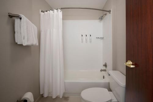 a bathroom with a white shower curtain and a toilet at SpringHill Suites by Marriott Little Rock in Little Rock