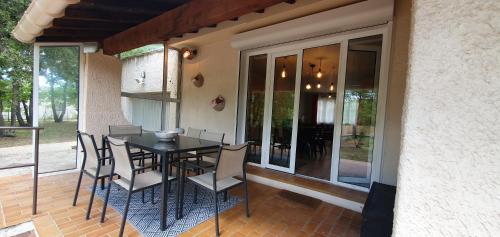 un patio avec une table et des chaises sur un balcon dans l'établissement Odette du Colorado, vue sur le colorado, jacuzzi, boisé, à Rustrel