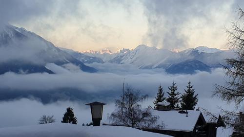 a view of a snowy mountain range with a foggy valley at Hotel Pension Tyrol in Seefeld in Tirol