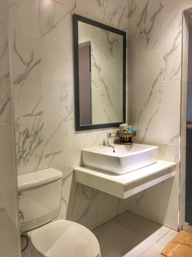 a bathroom with a sink and a toilet and a mirror at Diamond Park Inn Chiangrai & Resort in Chiang Rai