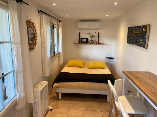 Petite chambre indépendante avec sdb, clim et parking privé في نيس: غرفة نوم عليها سرير ومخدات صفراء