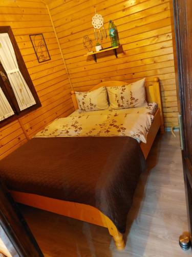 a bedroom with a bed in a wooden room at Dor de Munte Transfăgarasan in Cîrţişoara