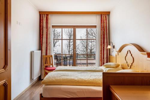 two beds in a room with a window at Apartments Mirabell in Livinallongo del Col di Lana