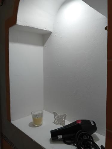 un tavolo con un telefono e un bicchiere sopra di Margy House a Morciano di Leuca